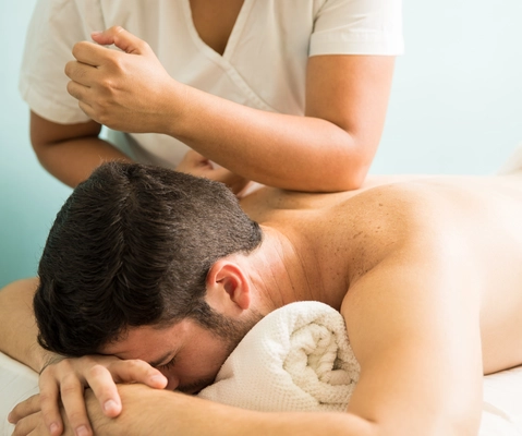 Customer receiving sports massage in a hotel room in Tooting, SW17
